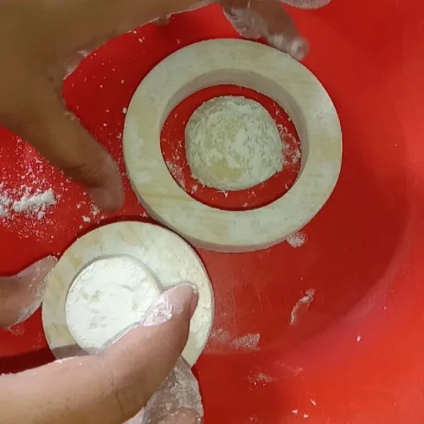 Setelah 10 menit, ambil kembali adonan donat lalu gulingkan ke tepung terigu (supaya tidak lengket) , lalu adonan tadi kita tekan sedikit dengan telapak tangan atau bisa pakai alat penekan donat. Ini berfungsi untuk mengeluarkan udara dalam donat, Tekan dengan pelan dan lembut jangan sampai gepeng ya.