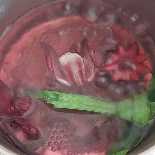 Rebus bersama pandan, kayu manis, dan cengkeh sampai air berubah jadi pink dan kelopak rosela memutih