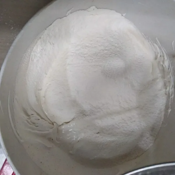 Masukkan tepung terigu, vanili bubuk, dan garam yang sudah diayak secara selang-seling dengan mentega yang sudah dicairkan. Aduk sampai semua tercampur rata.