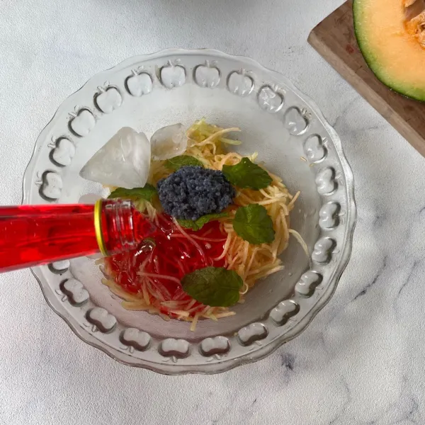 Tambahkan es batu dan sirup cocopandan.