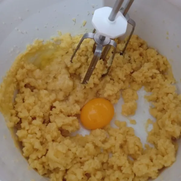 Lalu setelah agak hangat, masukkan telur 1 per satu sambil terus dimixer, pastikan semua tercampur rata.
