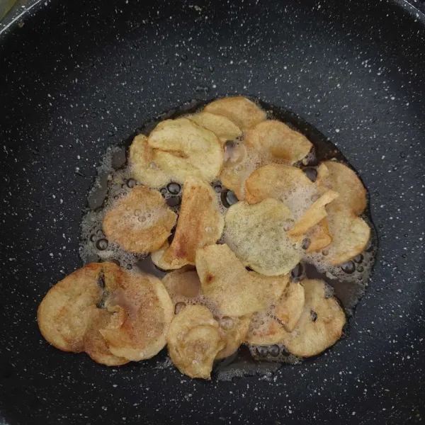 Iris tipis kentang, cuci beberapa kali, lalu goreng sampai kering
