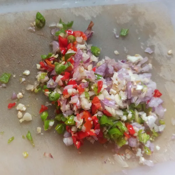 Cincang bawang merah, bawang putih, dan cabai rawit.