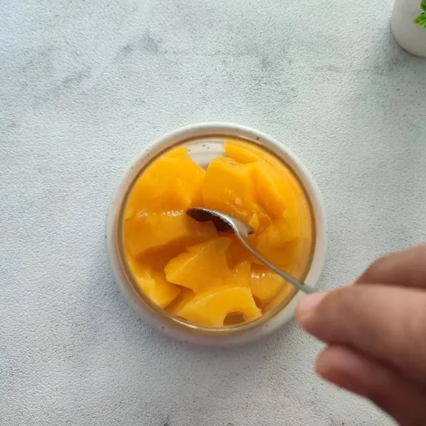 Siapkan gelas saji, masukkan 1 cup puding mangga sambil dihancurkan kasar.