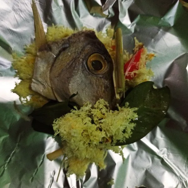 Siapkan alumunium foil atau daun pisang, kemudian masukkan kelapa parut yang sudah dibumbui, ikan peda diatasnya, dan daun salam.