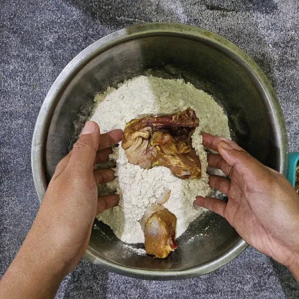 Gulingkan ayam ke tepung crispy lalu aduk-aduk dan banting-banting ayam, jangan di remas.