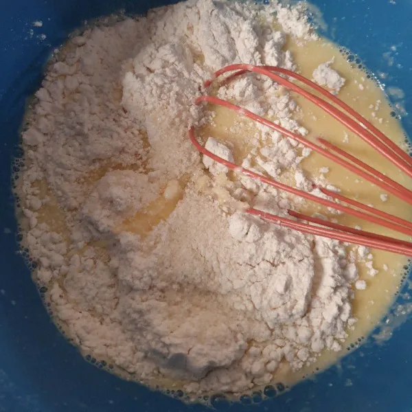 Masukkan tepung terigu dan gula pada adonan telur, aduk rata.