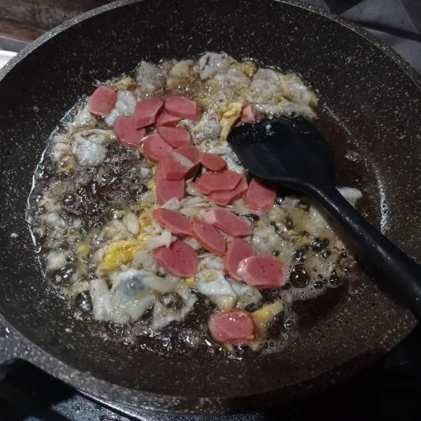 Buat telur orak-arik sampai matang, masukkan bawang putih dan sosis, masak sampai matang