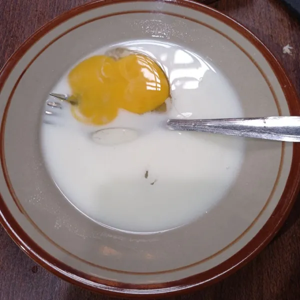 Kocok lepas telur dan susu cair di dalam wadah