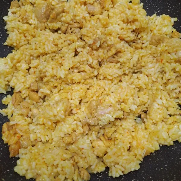 Masukkan nasi putih, aduk rata dengan tumisan ayam. Koreksi rasa sesuai selera.