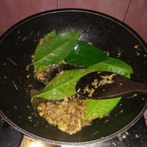 Tumis bumbu halus hingga harum, kemudian tambahkan daun salam. Tumis hingga matang.