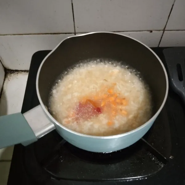 Setelah air agak menyusut, tambahkan potongan wortel, tomat dan santan. Aduk terus sampai air menyusut. Setelah hangat, haluskan lalu sajikan dengan keju belcube.