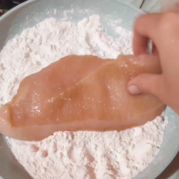 Lumuri ayam dengan tepung terigu.