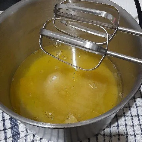 Dalam wadah, siapkan putih telur bersama SP dan gula pasir, kemudian kocok hingga kental berjejak