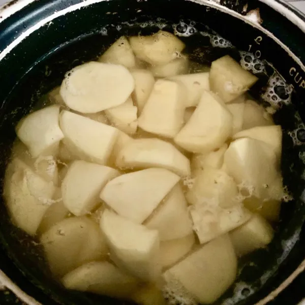 Kupas dan rebus kentang sampai empuk.