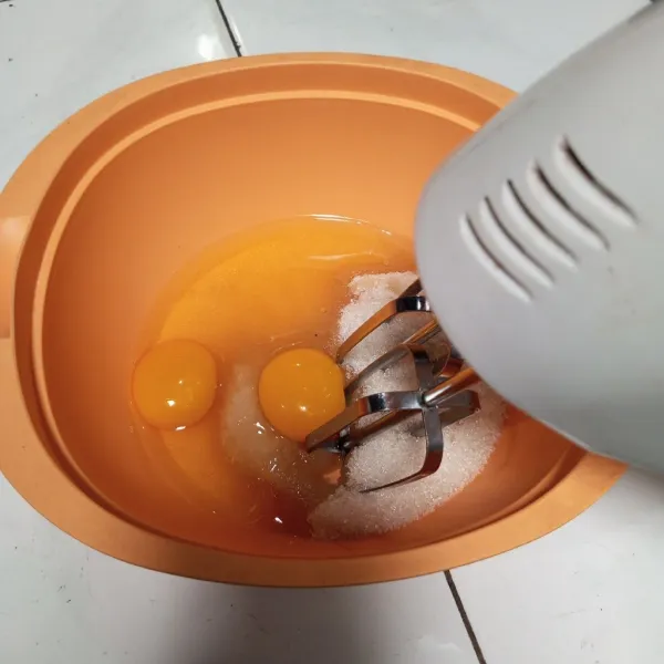 Mixer gula dan telur dengan kecepatan tinggi sampai putih.