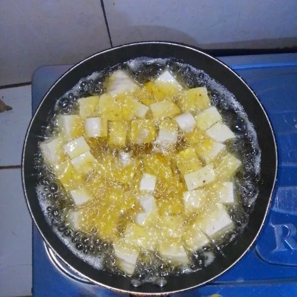 Pertama-tama goreng tahu dengan minyak panas hingga matang berwarna kuning keemasan.