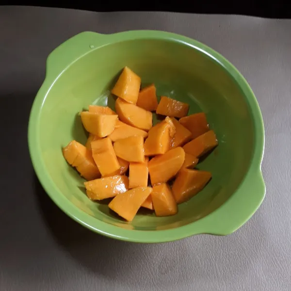 Kupas mangga dan potong dadu, masukkan dalam mangkok besar.