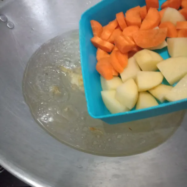 Tambahkan air, masukkan wortel dan kentang masak setengah matang.