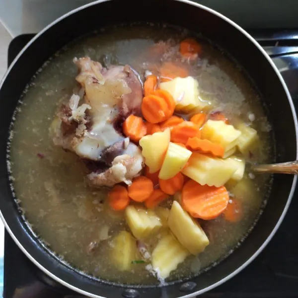 Masukkan wortel dan kentang, masak selama 10 menit.