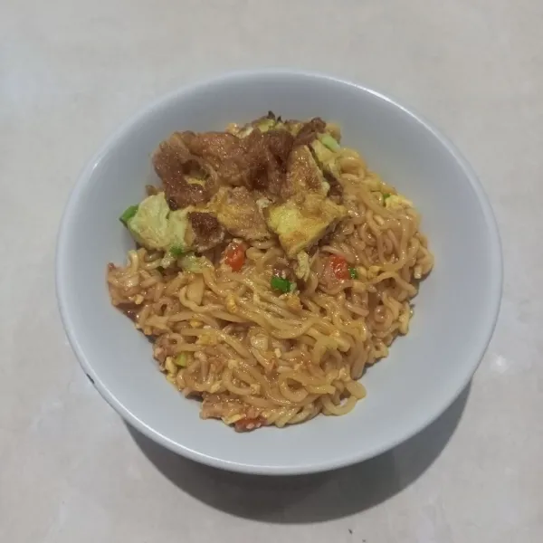 Goreng telur, tuangkan mie ke dalam mangkuk dan letakkan telur diatas mie.