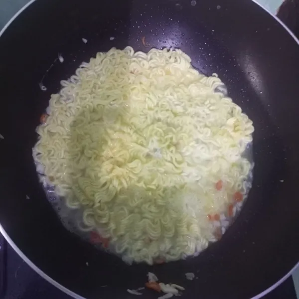 Aduk mie goreng hingga setengah matang.