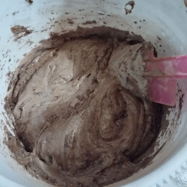 Lalu masukkan tepung terigu, vanili dan coklat bubuk. Sambil diayak. Campur asal rata.