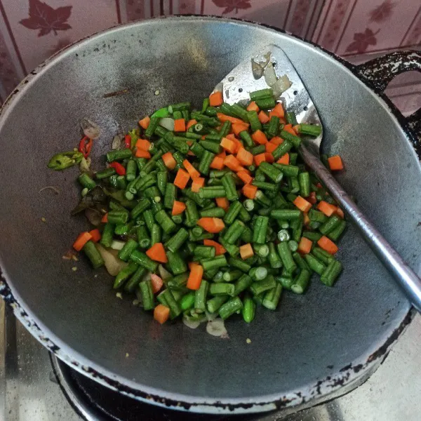 Selanjutnya masukkan kacang panjang dan wortel, tambahkan air secukupnya kemudian masak hingga setengah matang.