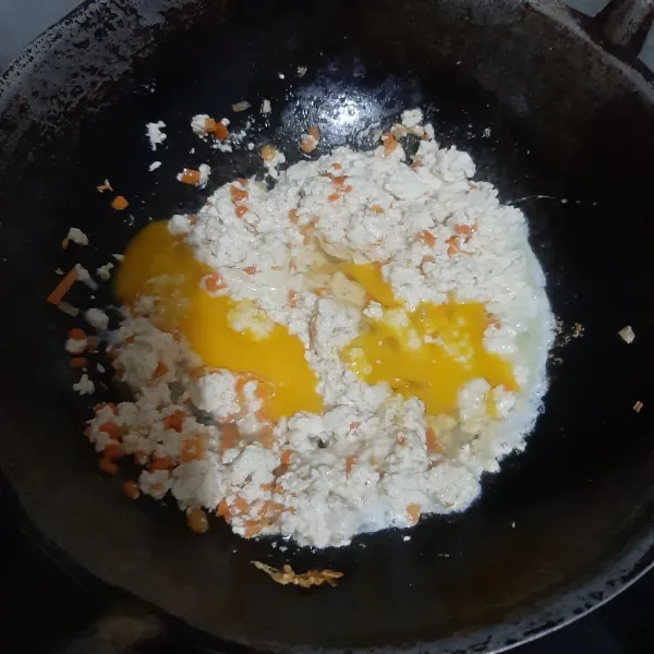 Masukkan tahu, aduk sebentar. Lalu masukkan telur. Beri chicken powder, garam, lada bubuk. Tes rasanya. Tunggu matang.