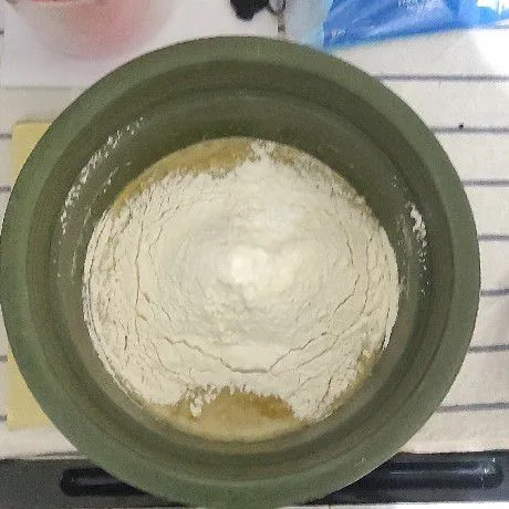Masukan tepung, vanila bubuk, garam dan soda kue ke adonan dengan diayak.