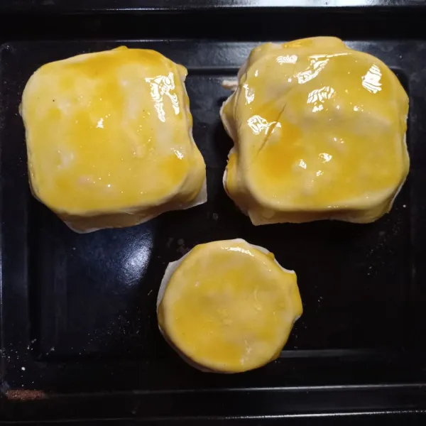 Tutup dengan puff pastry instan, olesi dengan kuning telur.