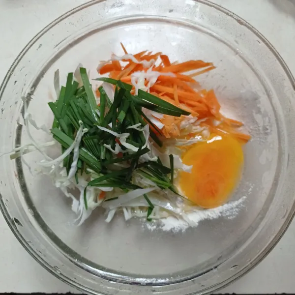 Masukan irisan wortel, kol, daun kucai, telur, tepung bakwan kedalam wadah, aduk rata.