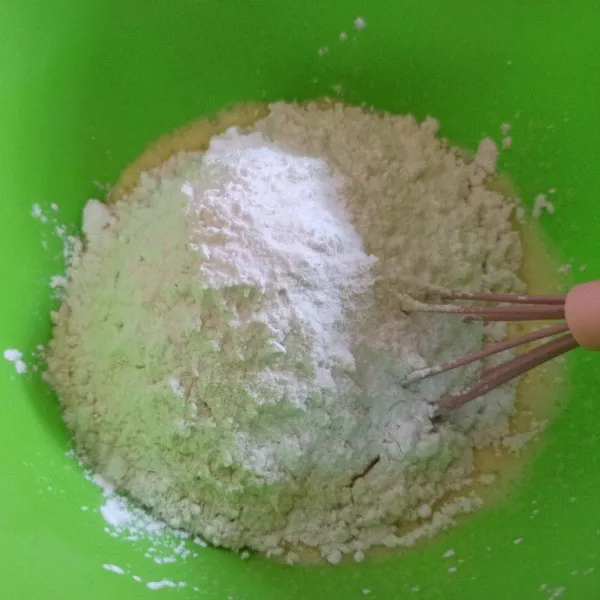 Selanjutnya masukkan tepung terigu, tapioka, soda kue, dan baking powder aduk, sambil tuang air sedikit demi aduk hingga tercampur rata.