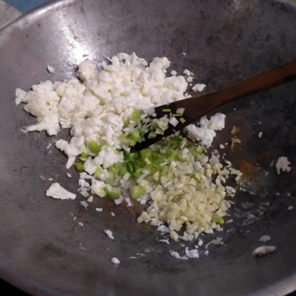 Tambah minyak lagi jika kurang, tumis bawang putih dan daun bawang bagian putih yang diiris halus. Masak sampai wangi, lalu aduk bersama putih telur.