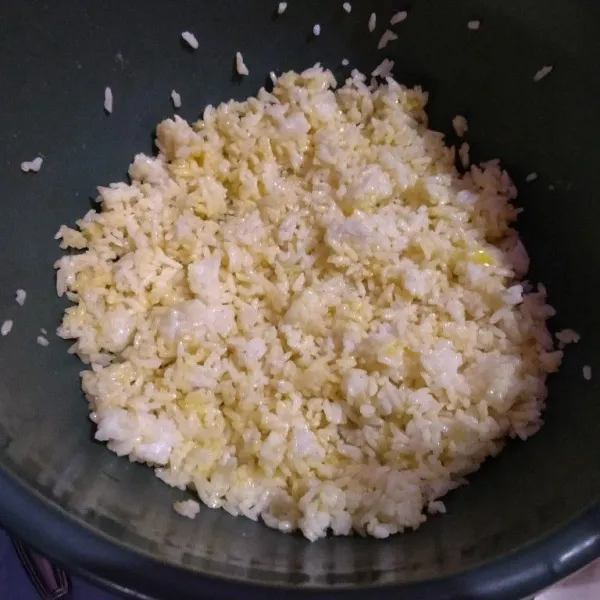 Pisahkan putih dan kuning telur. Bagian putih sisihkan untuk ditumis, yang kuning dicampur rata dengan nasi.