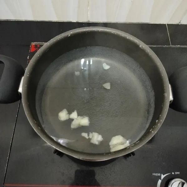 Rebus air dan bawang putih dalam panci hingga mendidih.