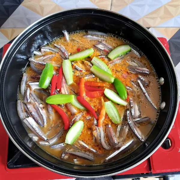 Tambahkan belimbing sayur dan cabai rawit, lalu tutup teflon, kemudian masak hingga matang dan air menyusut hampir kering. Lalu angkat dan sajikan.