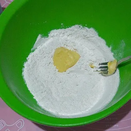 Campurkan tepung, garam, dan margarin, aduk rata hingga berpasir