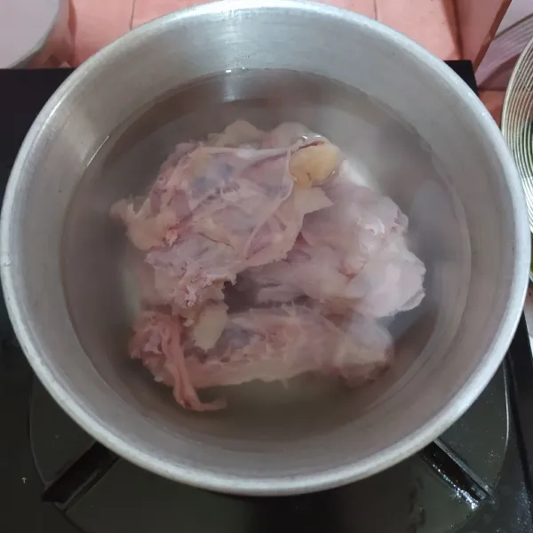 Siapkan tulang dada ayam, cuci bersih lalu masukkan ke dalam panci. Tuang air.