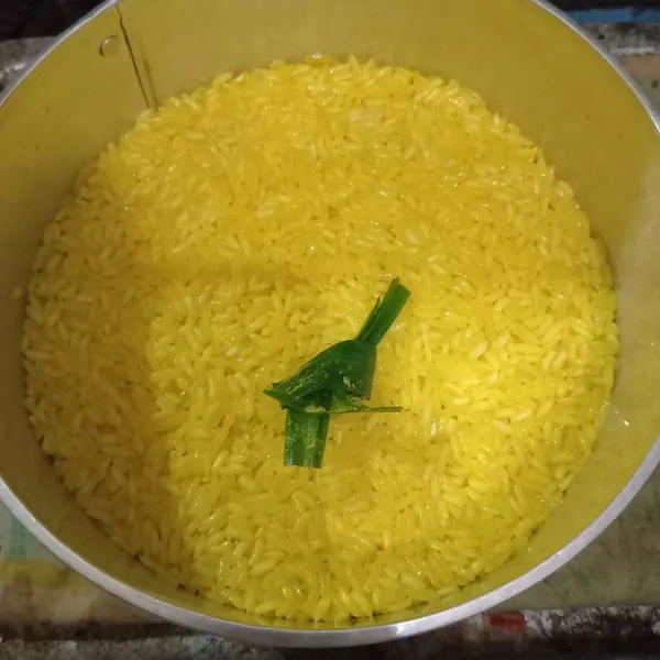 Masukkan beras ketan ke dalam loyang bulat yang sudah dioles minyak tipis-tipis. Ratakan dan rapikan beras ketan. Letakkan daun pandan di atasnya.