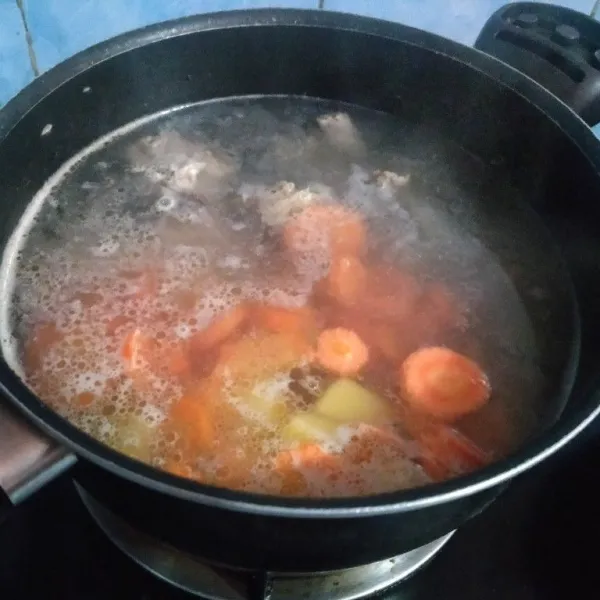 Masukkan potongan kentang dan wortel supaya cepat empuk.