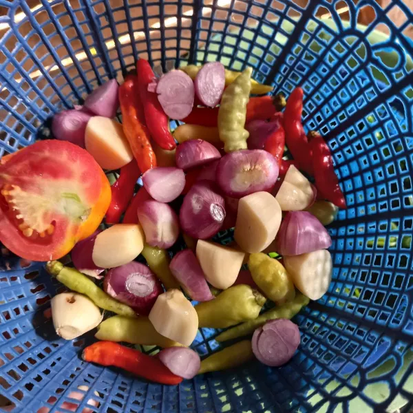 Uleg bawang merah, bawang putih dan cabe, uleg bersama garam dan gula sekalian. Untuk tomat saya iris saja.