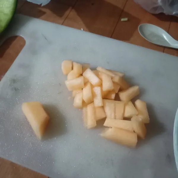 Potong memanjang buah melon.