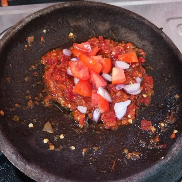 Tambahkan tomat dan bawang merah yang sudah dipotong-potong aduk rata dan masak hingga setengah matang.