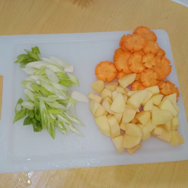 Potong tipis kentang, wortel dan daun bawang.