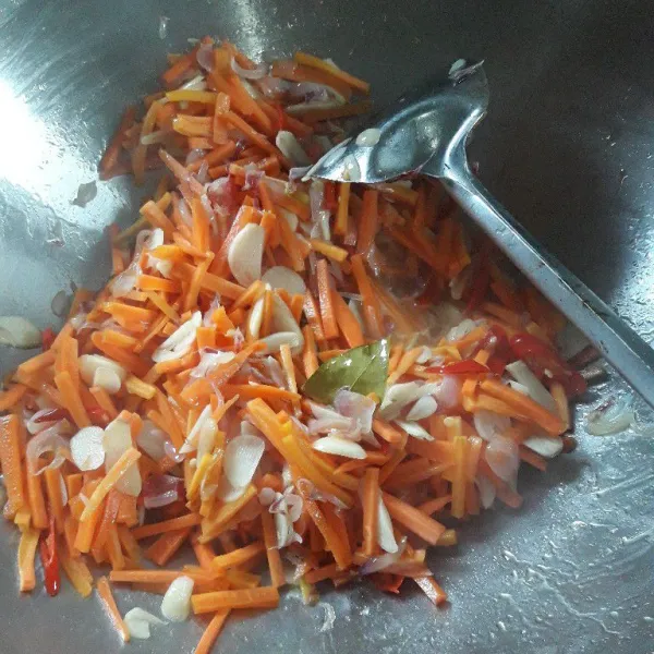 Masukkan wortel lebih dulu. Aduk rata, tambahkan air agar wortel cepat empuk. Masak sampai wortel setengah matang.