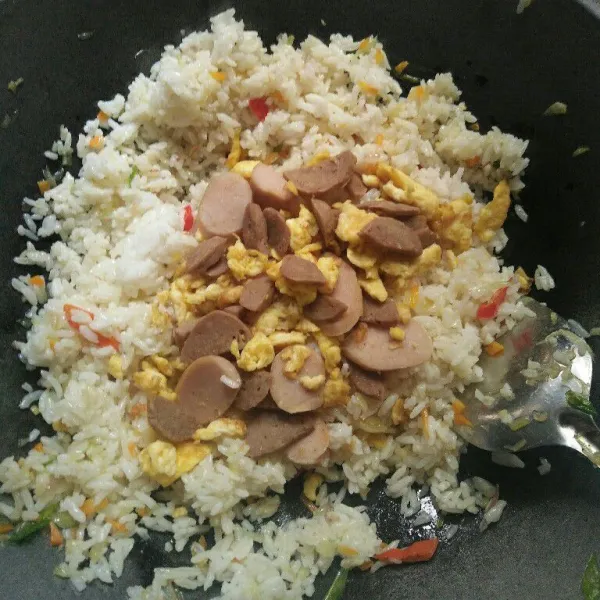 Masukan nasi, tambahkan telur, bakso dan sosis tadi lalu aduk-aduk masak hingga rata dan matang.