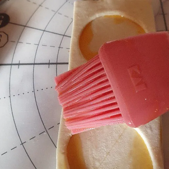 Tempelkan bagian berlubang di atasnya dan kemudian oles dengan kuning telur