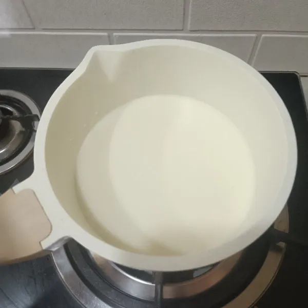 Larutkan susu dan bubuk jeli. Aduk merata dan masak di api kecil sampai mendidih.