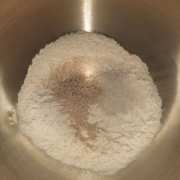 Dalam bowl masukkan tepung terigu, gula, dan ragi. Aduk perlahan hingga tercampur rata.